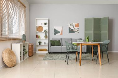 Gri kanepesi, masası ve sandalyeleri olan şık bir oturma odası.