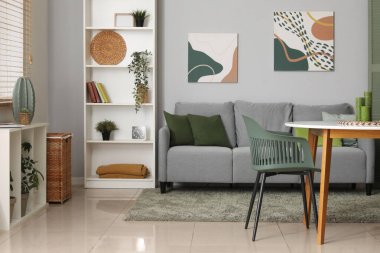 Gri kanepesi, masası ve sandalyeleri olan şık bir oturma odası.