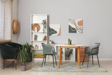 Modern oturma odası, siyah kanepe, masa ve raf ünitesi.