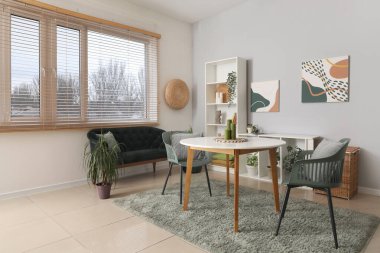 Masası, siyah rahat koltuğu ve raf ünitesi olan güzel bir oturma odası.