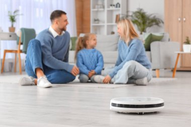 Robot elektrik süpürgesi ve ailesi evde, yakın çekim.