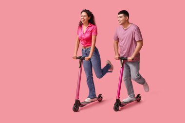 Pembe arka planda modern elektrikli scooter kullanan güzel bir çift.