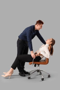 İş adamı, bayan meslektaşını arka planda taciz ediyor. Taciz konsepti