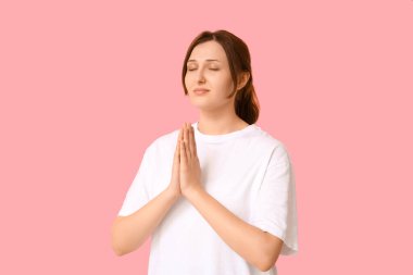 Pembe arka planda dua eden dindar genç bir kadın.