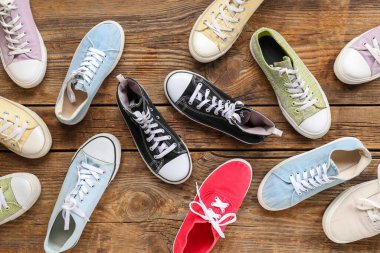 Ahşap arka planda farklı spor ayakkabılar. Üst görünüm