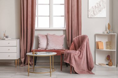 Pencerenin yanında yumuşak bir bank olan oturma odasının şık bir iç mekanı.