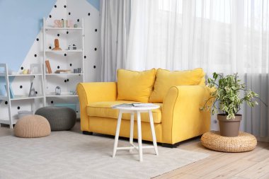 Sarı kanepe ve oturma odasının içindeki masa.