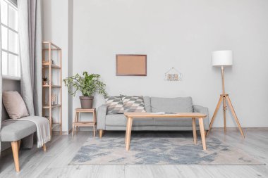 Oturma odası, kanepe ve ışık duvarının yanındaki masa.