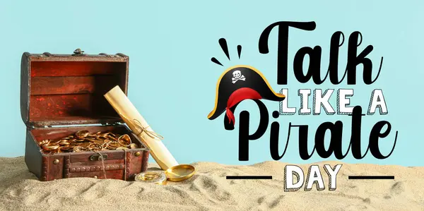 Stock image Old chest with treasure, map and compass on sand against light blue background. Banner for Talk Like a Pirate Day