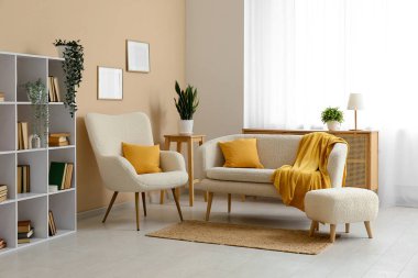 Rahat kanepesi, koltuğu, kitaplığı ve sarı ekoseli oturma odası.