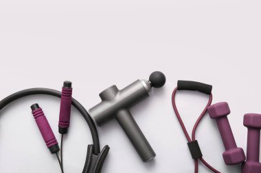 Hafif arkaplanda spor aletleri ve vurmalı masaj aleti.