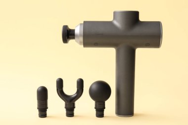 Renk arkaplanında farklı nozülleri olan vurmalı masaj aleti