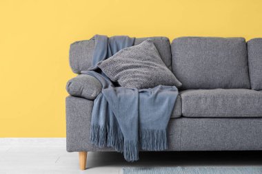 Güzel oturma odasının içinde siyah kanepe, ekose ve yastık, yakın çekim.