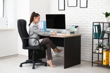 İşyerinde evrak işi yapan kadın ofis çalışanı.