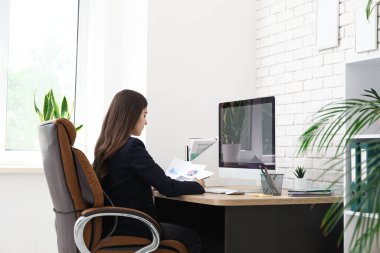 İş yerinde modern bilgisayar kullanan kadın ofis çalışanı.