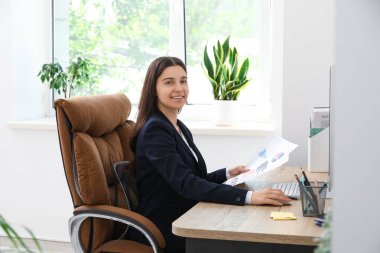 İşyerinde evrak işi yapan kadın ofis çalışanı.