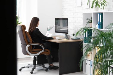 İş yerinde modern bilgisayar kullanan kadın ofis çalışanı.