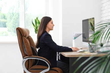 İş yerinde modern bilgisayar kullanan kadın ofis çalışanı.