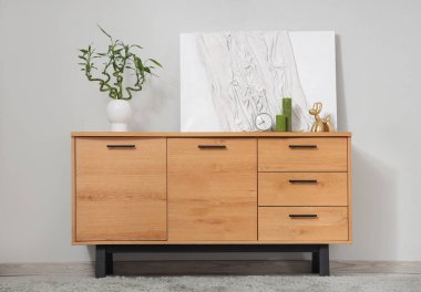 Dekor, bambu saplı ahşap dolap ve gri duvarın yanındaki resim.