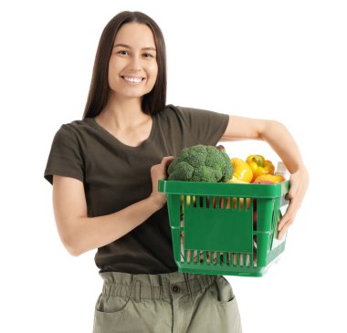 Beyaz arka planda alışveriş sepeti olan genç bir kadın.