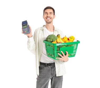 Beyaz arka planda alışveriş sepeti ve ödeme terminali olan genç bir adam.