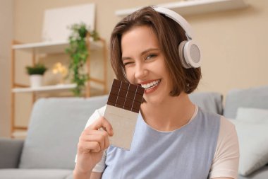 Evde lezzetli çikolatalı kulaklıklı güzel, mutlu bir kadın var.