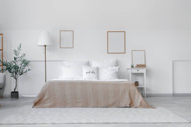 Yatak odasının içinde beyaz yastıklı rahat bir yatak.