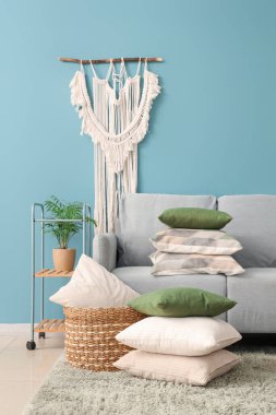 Gri kanepesi ve yastıkları olan rahat bir oturma odası.