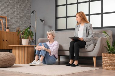 Ofiste oturan üzgün genç kız ve psikolog.