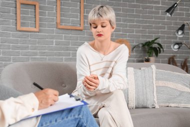 Üzgün genç kız psikologun ofisinde oturuyor.