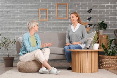 Ofiste genç bir kızla konuşan kadın psikolog.