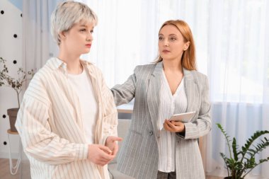 Tablet bilgisayarlı kadın psikolog ve ofiste üzgün genç kız.