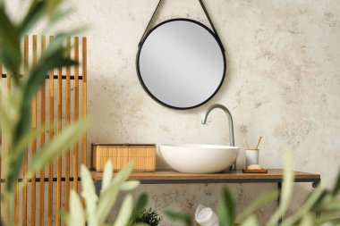 Modern banyoda şık bir lavabo ve dekoratif zeytin ağacı.