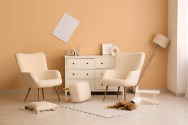 Depremden sonra koltukları ve çekmeceleri olan hasarlı oturma odasının içinde.