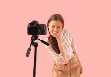 Pembe arka planda fotoğraf makinesi olan genç blog yazarı