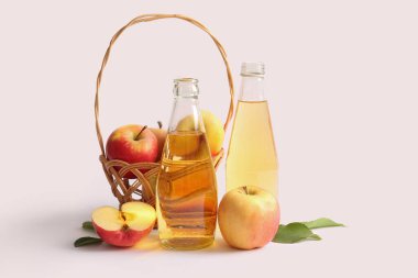 Taze elma şarabı şişeleri ve hafif arka planda meyveler.