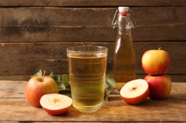 Ahşap arka planda meyve, şişe ve bir bardak taze elma şarabı ile kompozisyon