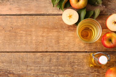 Ahşap zemin üzerinde meyve, peçete ve bir bardak taze elma şarabı olan kompozisyon