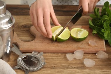 Mutfakta mojito için kireç kesen genç bir kadın.
