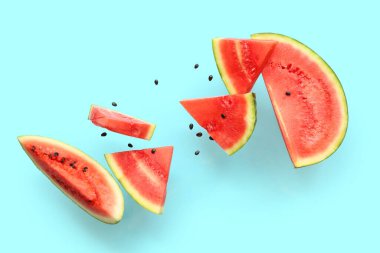 Uçan taze karpuz parçaları ve mavi arka planda tohumlar