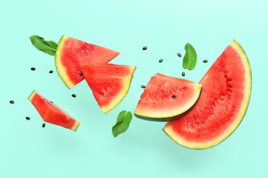 Uçan taze karpuz parçaları ve arkaplanda nane ve tohumlar.