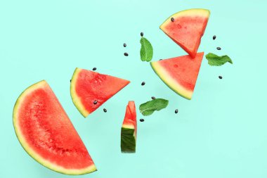 Uçan taze karpuz parçaları ve arkaplanda nane ve tohumlar.