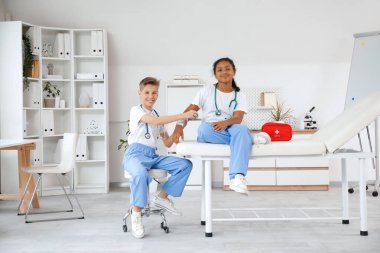 Genç doktor, klinikteki Afro-Amerikalı kıza bandaj uyguluyor.