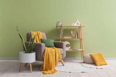 Yastıklı koltuk, ekose, raf ünitesi ve yeşil duvarın yanına bitki dikin.