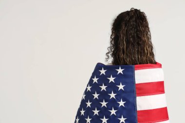 Beyaz arka planda Amerikan bayrağı olan güzel bir Afro-Amerikalı kadın.