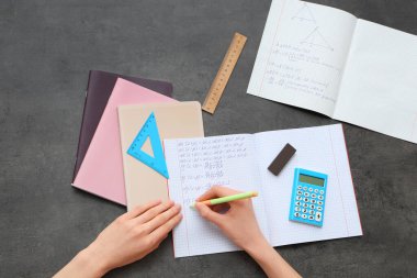 Matematik formüllerini koyu arkaplan üzerine yazan kadın