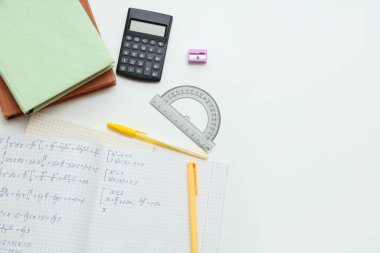 Işık arkaplanı üzerine matematik formülleri, kitaplar ve kırtasiye ile metin kitabı