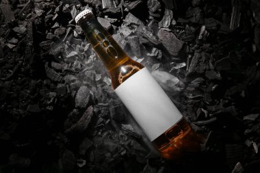 Kömürün üstünde bir şişe soğuk bira