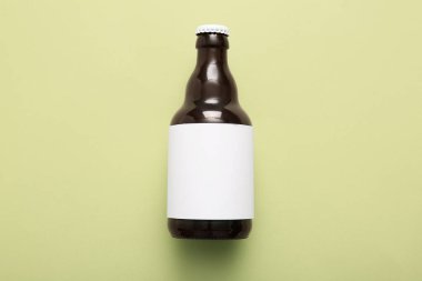 Yeşil arka planda bir şişe soğuk bira.