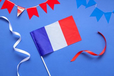 Mavi arka planda kurdeleleri ve kibritleri olan Fransa bayrağı. Bastille Günü kutlamaları